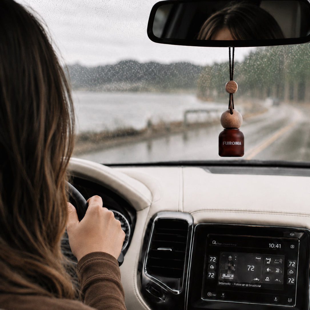 Person driving a car with a dashboard view, including Furoma air freshener hanging from the rearview mirror.